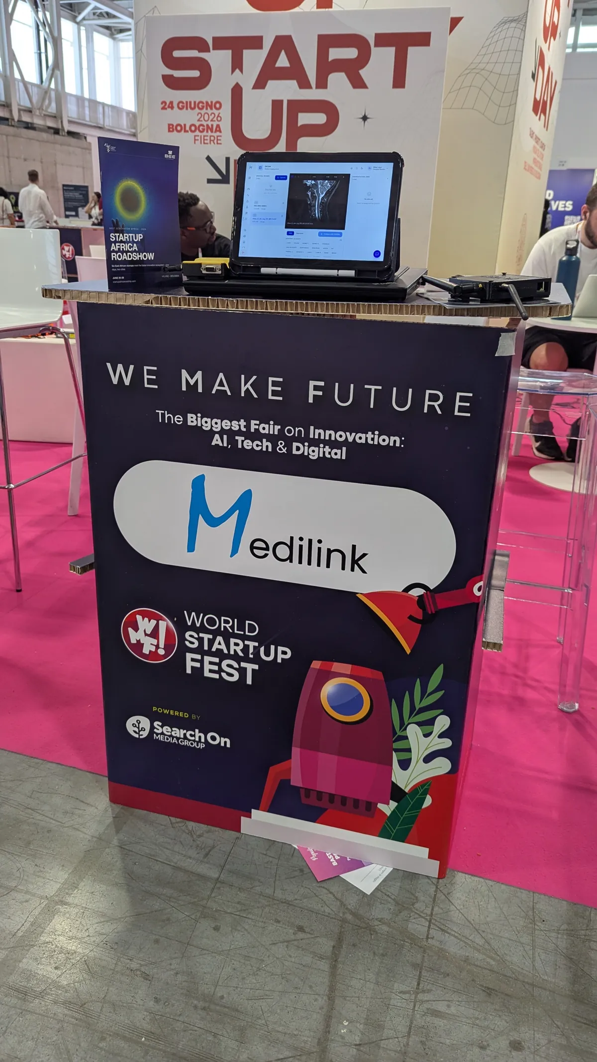 MediLink stand at World Startup Fest, with the platform running on a laptop